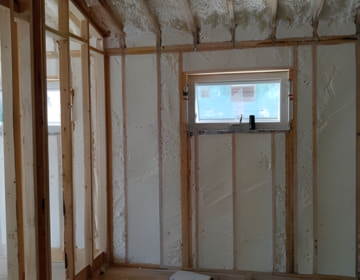 Closed cell spray foam insulation applied to wall cavities for superior thermal and sound insulation